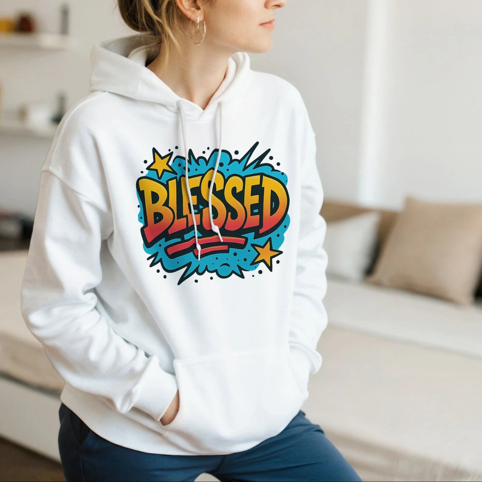 Woman wearing a white hoodie with 'BLESSED' print in a living room.