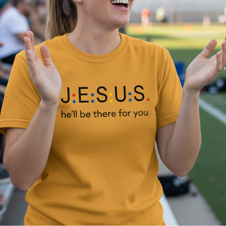 Woman clapping at a sports event wearing a yellow t-shirt with 'JESUS he'll be there for you' text.