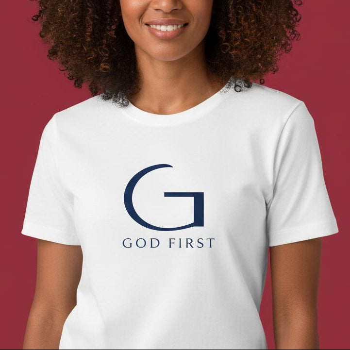 Woman wearing a white t-shirt with 'GOD FIRST' logo on a red and beige background
