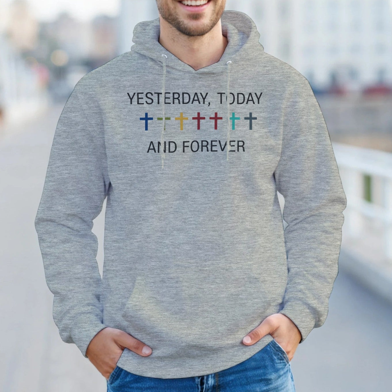 Man wearing a gray hoodie with text and symbols outdoors