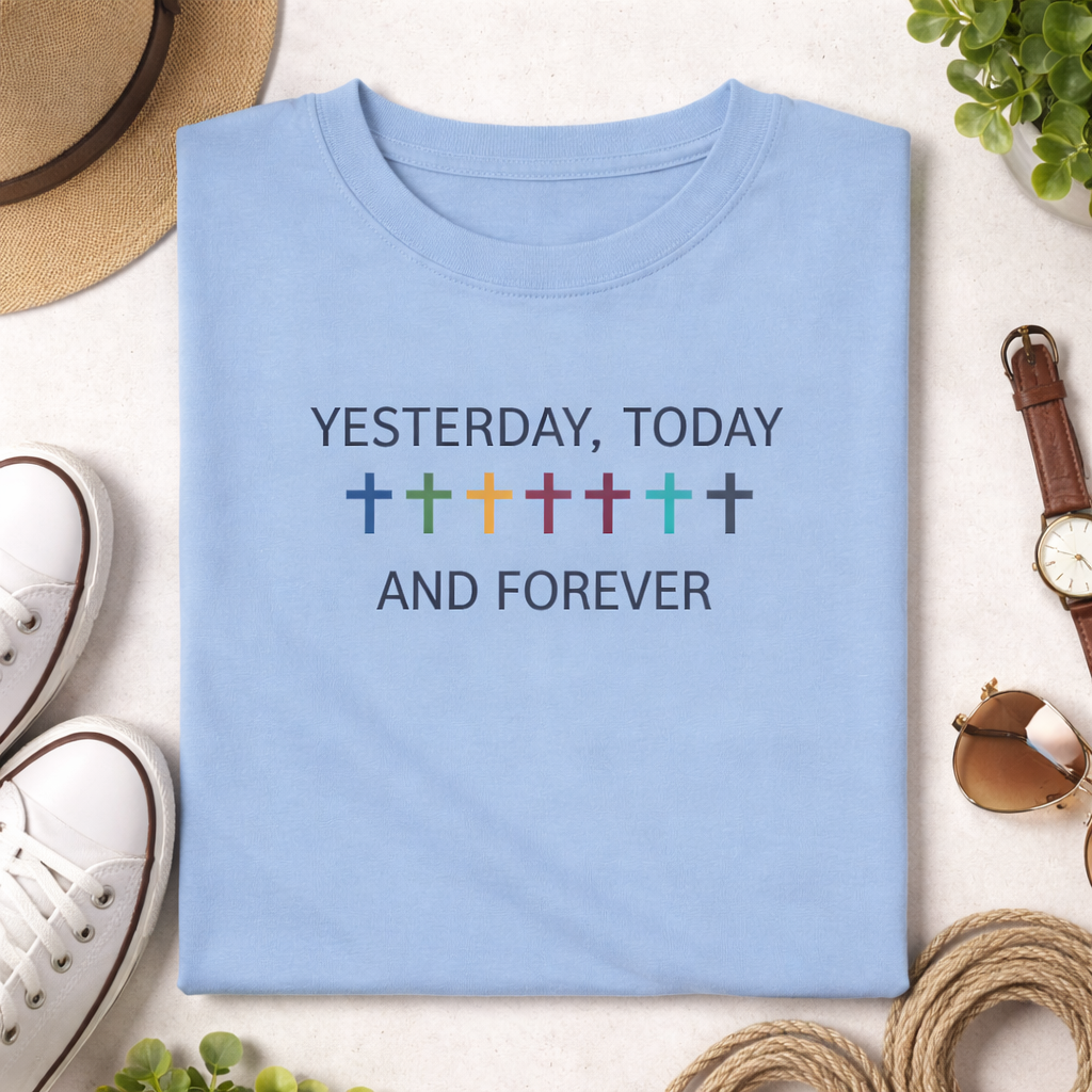 Light blue t-shirt with 'Yesterday, Today and Forever' text and colorful crosses on a white surface with accessories.