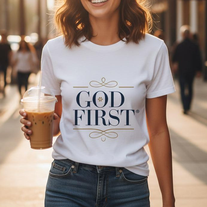 Woman wearing a 'GOD FIRST' t-shirt on a city street.