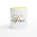 White mug with yellow interior and 'GOD FIRST' text on a white background