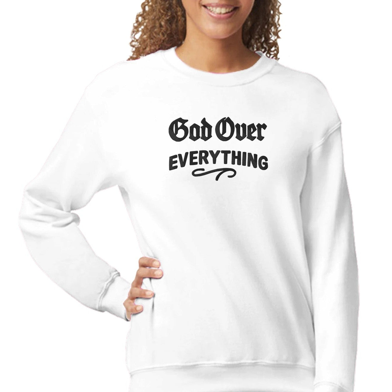 Woman wearing a white sweatshirt with 'God Over Everything' text on a white background