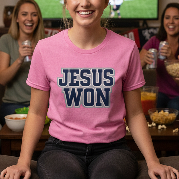Woman wearing a 'Jesus Won' shirt sitting in front of a TV with sports fans in the background.