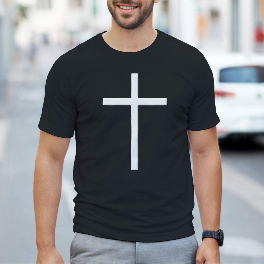 Man wearing a black t-shirt with a white cross on a city street