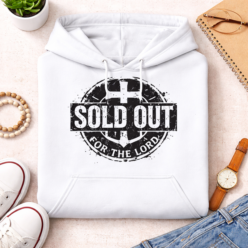 White hoodie with 'Sold Out for the Lord' text on a light surface with accessories.