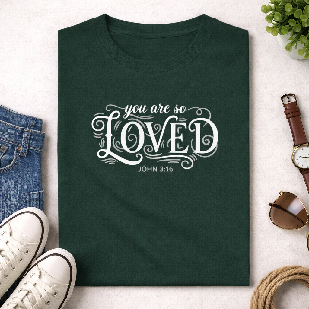 Green t-shirt with 'you are so LOVED' text on a light surface with accessories around